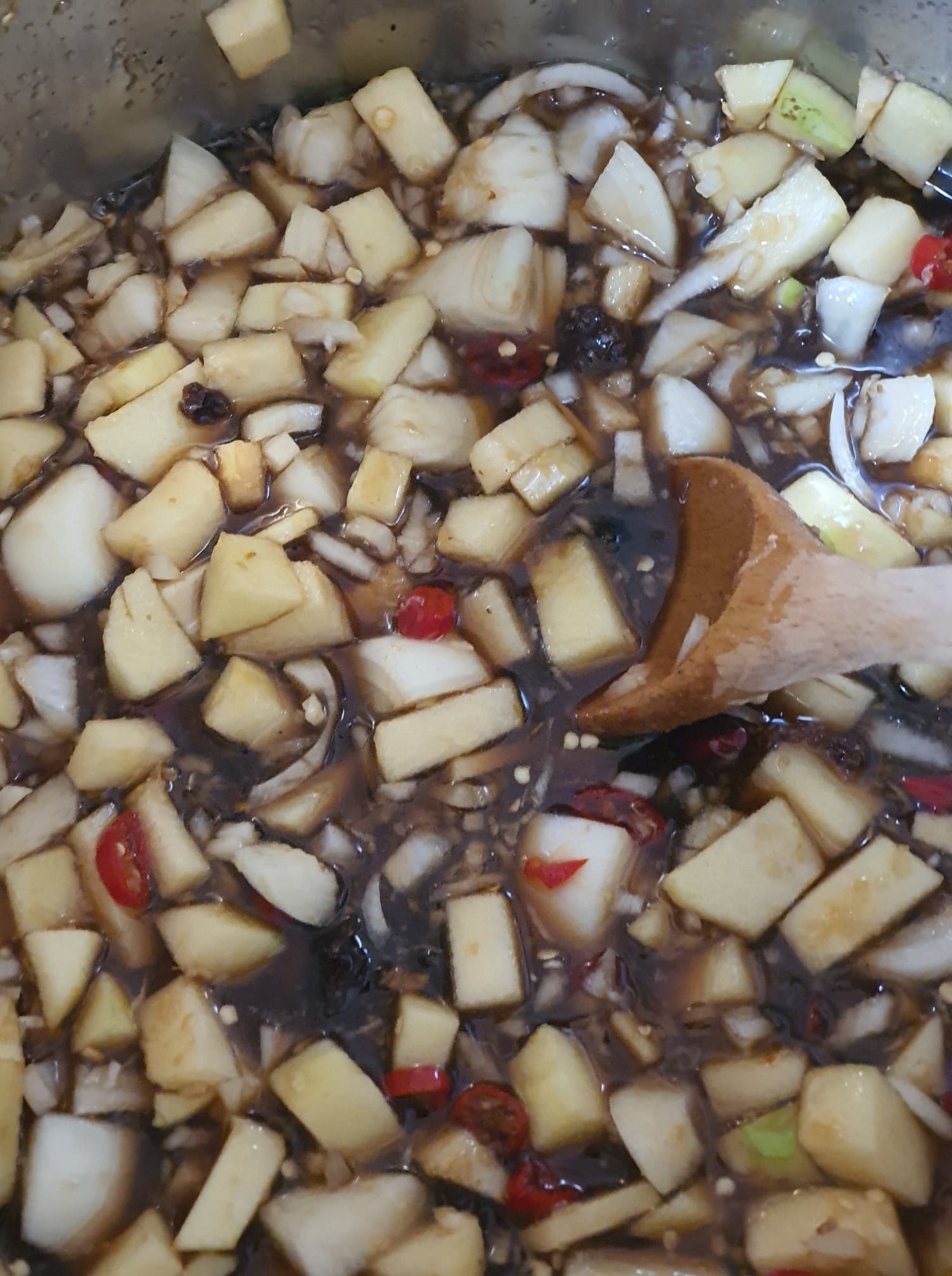 diced apple, chilli, onion and other ingredients inside a cooking pot